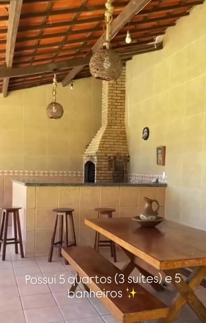 Churrasqueira de alvenaria do deck, com bancada e banquetas de madeira