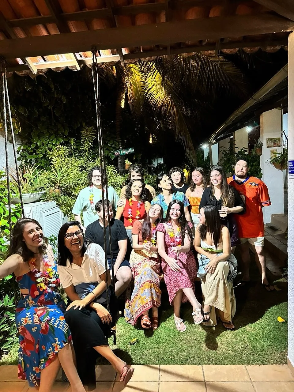 Grupo grande de hóspedes reunido no jardim da casa