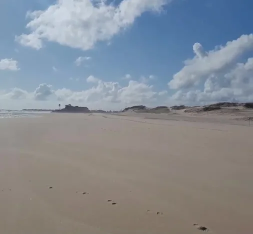 A faixa de areia da Praia da Caponga, com as dunas ao fundo